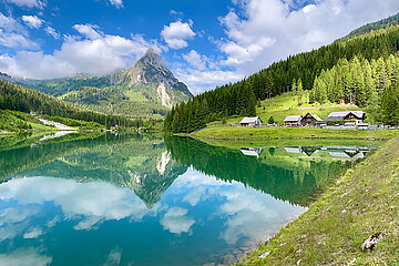 Ein glasklarer Bergsee im Salzburger Lungau spiegelt einen massiven Berggipfel