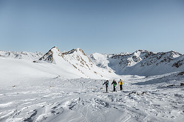 Mit Almliesl Urlaub in Tirol buchen Drei Skitourengeher unterwegs zum verschneiten Gipfel