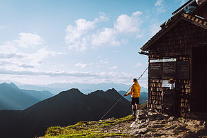Regionstipp der Woche Ein Wanderer genießt die Aussicht auf die Bergwelt bei Sonnenschein